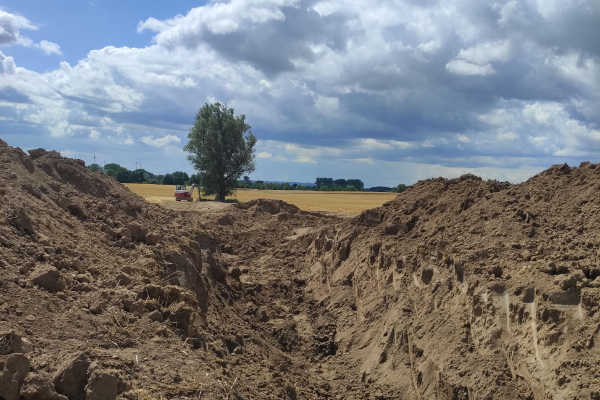 Anfangsarbeiten einer Drainage auf einem Feld - ausgehobener Graben