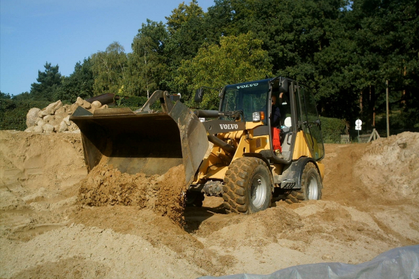 Vorderlader gibt Sand auf den Boden