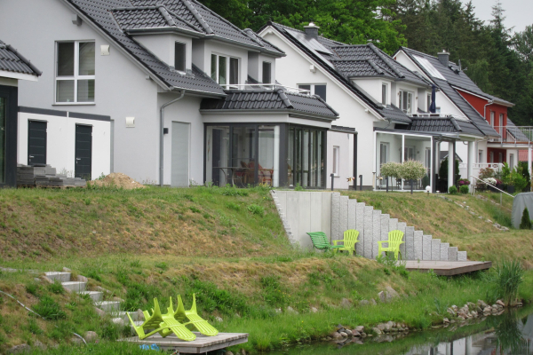 Winkelstutzen am Kanalufer - dahinter Einfamilienhäuser