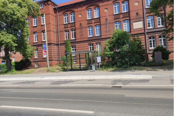 Gepflasterter Gehweg vor einer Bushaltestelle